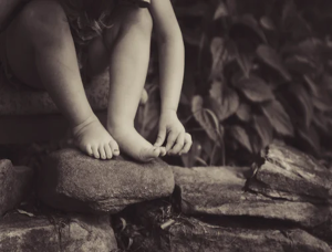 A child 's feet are shown on the ground.
