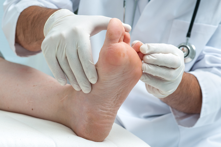 A person is getting their foot examined by a doctor.