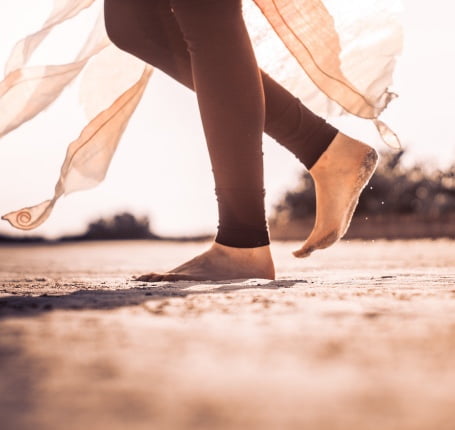 A person walking on the ground with their feet in the air.